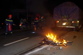 Cảnh sát Phòng cháy chữa cháy tham gia dập lửa tại hiện trường vụ tai nạn. (Ảnh: Nguyễn Dũng/TTXVN) 