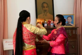Bà Nhotkeomaly Suphanouvong và con gái đang chuẩn bị đồ lễ thắp hương tại Bàn thờ Chủ tịch Hồ Chí Minh trong Khu lưu niệm Chủ tịch Suphanouvong ở thủ đô Vientiane. (Ảnh: Phạm Kiên/Vietnam+)