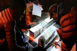 Các chiến sỹ thuộc Phòng Cảnh sát điều tra tội phạm về ma túy đang kiểm tra tang vật bị thu giữ. (Ảnh: Thái Thuần/TTXVN)