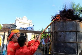 Các nghệ nhân thực hiện đúc súng thần công bằng phương pháp thủ công tại đền thờ Hoàng đế Quang Trung. (Ảnh: BÍch Huệ/TTXVN)