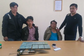 Hai đối tượng cùng tang vật bị thu giữ tại cơ quan điều tra. (Ảnh: Xuân Tư/TTXVN)