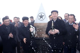 Chủ tịch nước Trần Đại Quang cùng các đại biểu chúc mừng Lễ thượng cờ thành công tốt đẹp tại cột mốc 3.143m. (Ảnh: Nhan Sáng/TTXVN)