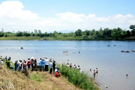 Lực lượng cứu hộ tìm kiếm thi thể học sinh bị đuối nước trên sông Ba. (Ảnh: Thế Lập/TTXVN)