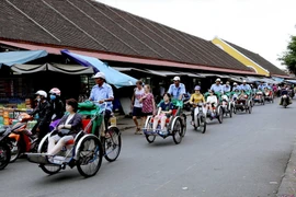 Du khách quốc tế tham quan phố cổ Hội An bằng xích lô. (Ảnh: Quang Quyết/TTXVN)