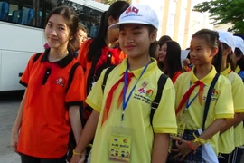 Thiếu nhi Việt Nam (áo màu đỏ) nắm chặt tay thiếu nhi Lào, biểu thị cho tình đoàn kết hữu nghị đặc biệt, sự hiểu biết lẫn nhau giữa thiếu nhi hai nước. (Ảnh: Phan Sáu/TTXVN)