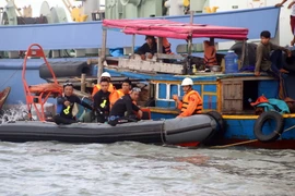 Tìm kiếm nạn nhân một vụ chìm sà lan. (Nguồn: TTXVN)
