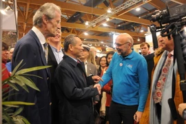 Đại sứ Việt Nam tại Vương quốc Bỉ Vương Thừa Phong gặp gỡ khách tham quan gian hàng Việt Nam. (Ảnh: Kim Chung/​TTXVN)