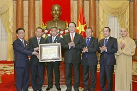 Chủ tịch nước Trần Đại Quang tặng quà cho Đoàn đại biểu kiều bào Việt Nam tại Thái Lan. (Ảnh: Nhan Sáng/TTXVN)