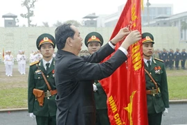 Chủ tịch nước Trần Đại Quang gắn Huân chương Quân công hạng Nhất lên lá cờ truyền thống của Bộ Tư lệnh Binh chủng Đặc công. (Ảnh: Nhan Sáng/TTXVN)