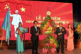 Chủ tịch Ủy ban Nhân dân tỉnh Thừa Thiên-Huế Nguyễn Văn Cao (bên phải) tặng hoa chúc mừng Trường Đại học Sư phạm Huế nhân kỷ niệm 60 năm thành lập. (Ảnh: Quốc Việt/TTXVN)