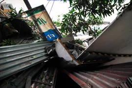 Khoảng 8 giờ tại khu nhà trong ngõ 72 Thợ Nhuộm (Hoàn Kiếm, Hà Nội), một khối bêtông kèm vật liệu xây dựng đã bất ngờ đổ ập lên mái một dãy 3 ngôi nhà trong ngõ. (Ảnh: Võ Phương/Vietnam+)