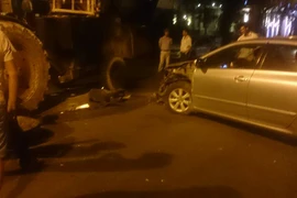 Chiếc ôtô phóng nhanh, lạng lách đâm thẳng vào xe máy kéo đang dừng chờ đèn đỏ. (Ảnh: Tiến Đạt/Vietnam+)