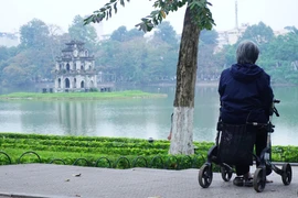 Hà Nội sớm mồng Một, mỗi người một cách đón nhận. (Ảnh: Võ Phương/Vietnam+)