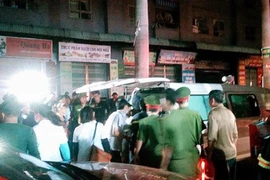 Đưa một người bị ngạt trong đám cháy đi cấp cứu. (Ảnh: Sơn Bách/Vietnam+)