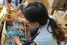 Lực lượng chức năng Hà Nội kiểm đếm số bánh Trung Thu không rõ nguồn gốc. (Ảnh: TTXVN phát)