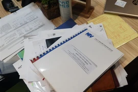 Các tài liệu quan trọng bị lực lượng chức năng niêm phong và thu giữ tại trụ sở FLC. (Ảnh: Phạm Kiên/TTXVN)