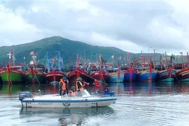 Bộ đội Biên phòng Quảng Bình tuyên truyền, hướng dẫn ngư dân neo đậu, chằng chống tàu đảm bảo an toàn tại khu vực tránh trú. (Ảnh: TTXVN phát)