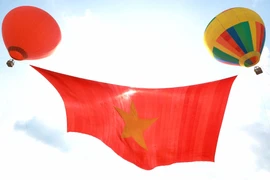 Thành phố Hồ Chí Minh dùng 2 khinh khí cầu lớn để kéo lá đại kỳ trên sông Sài Gòn. (Ảnh: Thu Hương/TTXVN)