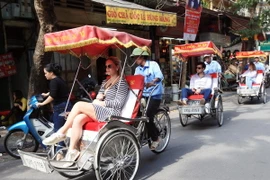 Du khách quốc tế thăm Hà Nội bằng xích lô. (Ảnh: Anh Tuấn/TTXVN)