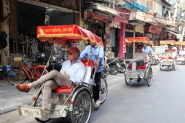 Du khách quốc tế thăm Hà Nội bằng xích lô. (Ảnh: Anh Tuấn/TTXVN)