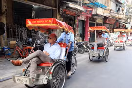 Du khách quốc tế thăm Hà Nội bằng xích lô. (Ảnh: Anh Tuấn/TTXVN)