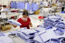 Kiểm tra thành phẩm sản phẩm áo sơ mi. (Ảnh: An Hiếu/TTXVN)