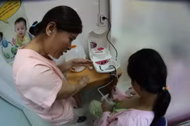 Nhân viên y tế hướng dẫn các bà mẹ đến hiến tặng sữa cách sử dụng máy hút sữa. (Ảnh: Trần Lê Lâm/TTXVN)