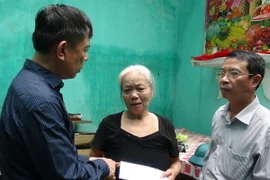 Chủ tịch UBND tỉnh Quảng Bình Nguyễn Hữu Hoài (trái) thăm động viên một hộ gia đình ở thị trấn Đồng Lê, huyện Tuyên Hóa, bị sập nhà do bão số 10. (Ảnh: Đức Thọ/TTXVN)