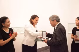 Bà Lévai Katalin, Quốc vụ khanh Bộ Nguồn nhân lực Quốc gia Hungary trao Huân chương cho dịch giả Giáp Văn Chung. (Ảnh: Nguyễn Hoàng Linh/Vietnam+)