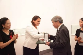Bà Lévai Katalin, Quốc vụ khanh Bộ Nguồn nhân lực Quốc gia Hungary trao Huân chương cho dịch giả Giáp Văn Chung. (Ảnh: Nguyễn Hoàng Linh/Vietnam+)