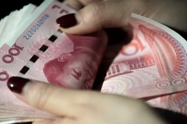 Đồng Nhân dân tệ tại một ngân hàng ở Bắc Kinh, Trung Quốc. (Ảnh: AFP/TTXVN)