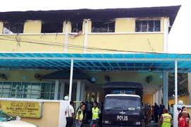 Lực lượng cảnh sát và cứu hộ làm nhiệm vụ tại hiện trường vụ hỏa hoạn. (Ảnh: AFP/TTXVN)