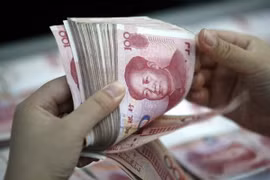 Kiểm đồng nhân dân tệ tại một ngân hàng ở tỉnh An Huy của Trung Quốc. (Ảnh: EPA/TTXVN)