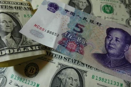 Đồng USD và đồng nhân dân tệ. (Ảnh: AFP/TTXVN)