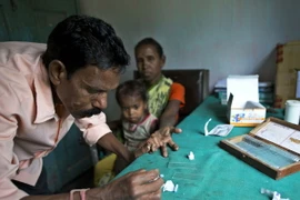 Nhân viên y tế lấy máu xét nghiệm từ bệnh nhân sốt rét tại Gauhati, Ấn Độ. (Ảnh: AP/TTXVN)