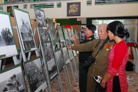 Nghệ sỹ nhiếp ảnh Minh Lộc - giữa - giới thiệu về các tác phẩm của mình tại triển lãm. (Ảnh: Mạnh Linh/TTXVN)