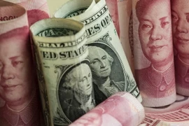 Tiền giấy mệnh giá 100 nhân dân tệ của Trung Quốc và đồng USD. (Ảnh: AFP/TTXVN)