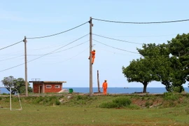 Sửa chữa lưới điện hạ thế trên đảo. (Ảnh: Ngọc Hà/TTXVN)
