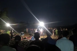 Các cơ quan chức năng đang tiến hành khám nghiệm tử thi điều tra nguyên nhân vụ việc. (Ảnh Quang Đán/TTXVN) 