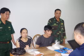 Lực lượng chức năng lấy lời khai 2 đối tượng. (Ảnh: Nguyễn Hoàng/TTXVN)