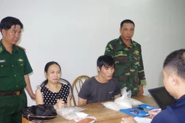 Lực lượng chức năng lấy lời khai 2 đối tượng. (Ảnh: Nguyễn Hoàng/TTXVN)
