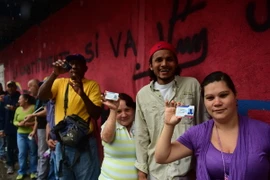 Người dân Venezuela xếp hàng chờ bỏ phiếu tại điểm bầu cử ở Caracas ngày 30/7. (Ảnh: AFP/TTXVN)