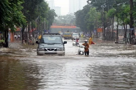 Mưa lớn gây ngập sâu tại khu vực đường Thái Hà mới ở quận Đống Đa gây ảnh hưởng đến đến việc đi lại của người dân. (Ảnh: Quang Quyết/TTXVN)