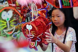 Các em thiếu nhi thích thú lựa chọn lồng đèn. (Ảnh: An Hiếu/TTXVN)