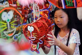 Các em thiếu nhi thích thú lựa chọn lồng đèn. (Ảnh: An Hiếu/TTXVN)