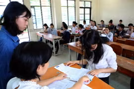 Hướng dẫn thí sinh làm thủ tục thi. (Ảnh: Trần Lê Lâm/TTXVN)