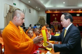 Chủ tịch Ủy ban Trung ương MTTQ Việt Nam Nguyễn Thiện Nhân tặng quà cho các đại biểu. (Ảnh: Nguyễn Dân/TTXVN)