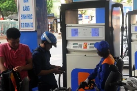 Khách hàng mua xăng tại cửa hàng kinh doanh xăng dầu trên phố Trần Hưng Đạo, quận Hoàn Kiếm, Hà Nội. (Ảnh: Quang Quyết/TTXVN)