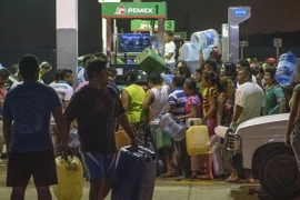 Người dân ăn cắp xăng và dầu diesel từ một trạm xăng trong cuộc biểu tình ngày 3/1 vừa qua để chống lại việc tăng giá nhiên liệu của Mexico. (Nguồn: AP)