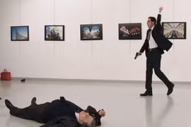 Hung thủ Mevlut Altintas (phải) sau khi sát hại Đại sứ Nga Andrei Karlov (trái) ở Ankara, Thổ Nhĩ Kỳ ngày 19/12/2016. (Ảnh: AFP/TTXVN)